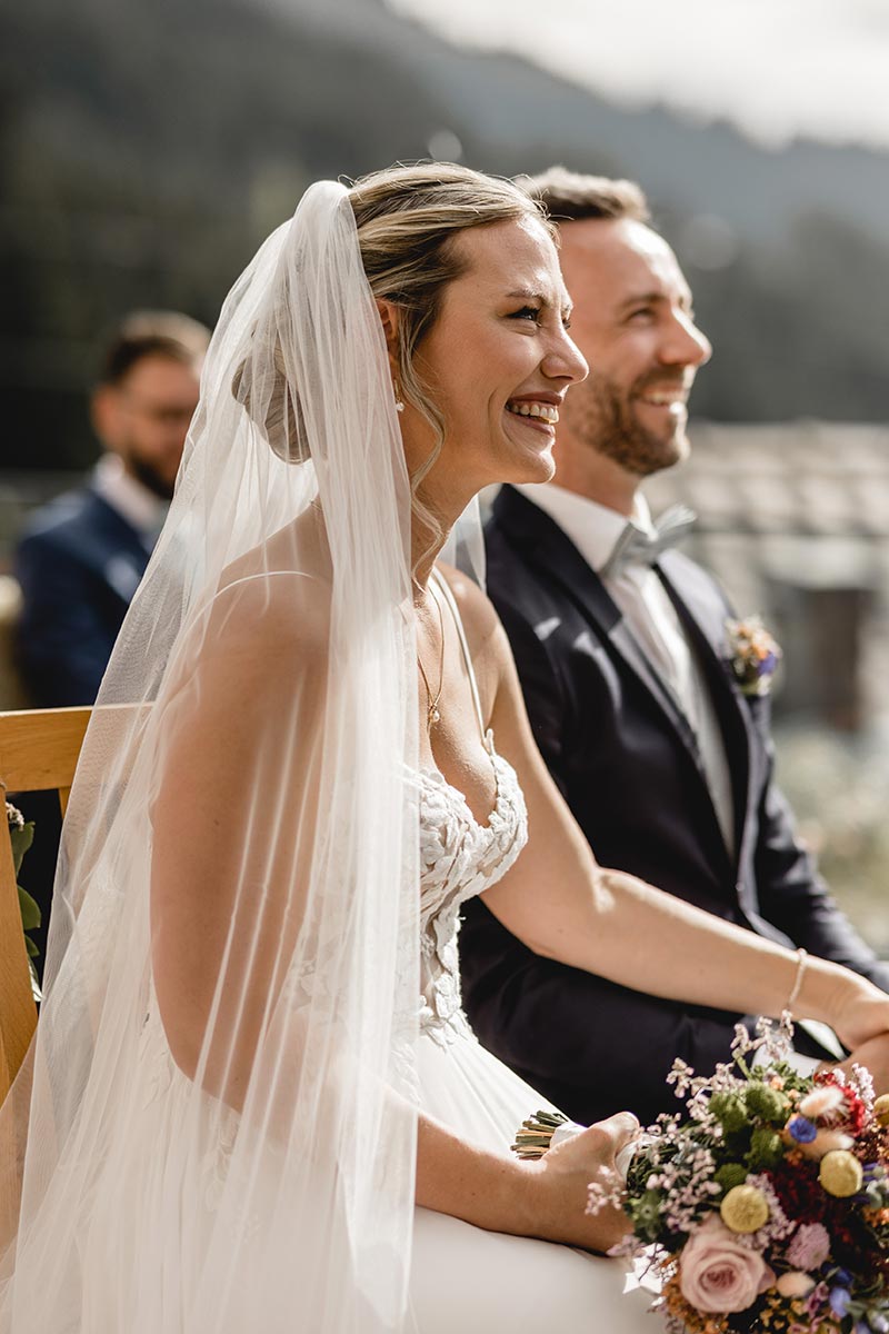 Brautpaar lacht während der freien Trauung unter freiem Himmel auf Rügen – emotionale Zeremonie