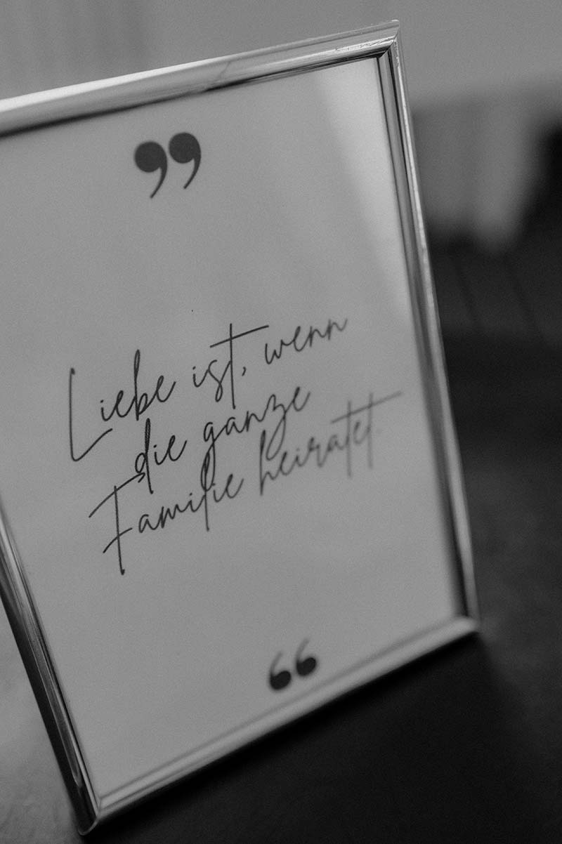 Dekoschild mit dem Spruch ‚Liebe ist, wenn die ganze Familie heiratet‘ – Detail einer freien Trauung auf Rügen