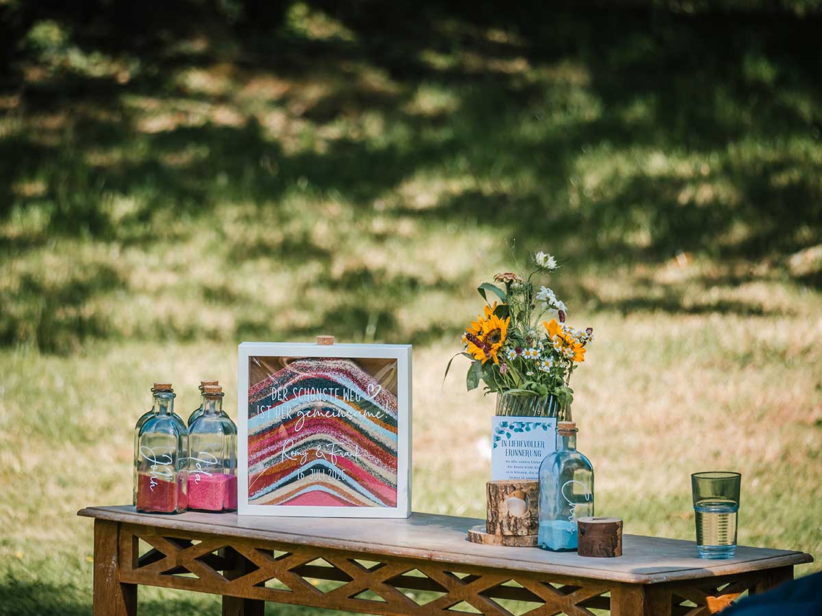 Sandritual mit buntem Sand und Blumenarrangement bei einer freien Trauung auf Rügen